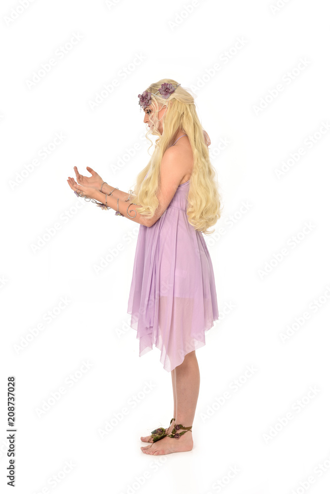 full length portrait of pretty blonde girl wearing purple fairy dress. standing pose, isolated on white studio background. full length portrait of pretty blonde girl wearing purple fairy dress. standing pose, isolated on white studio background.