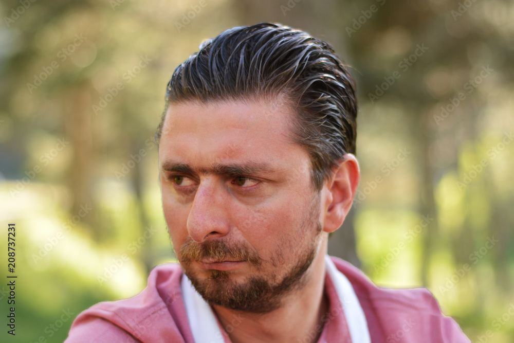 Young man's outdoors portrait looking at the camera with natural green background. Neutral, happy, sad, angry, disgust, fear, surprise Facial Emotions. Young man's outdoors portrait looking at the camera with natural green background. Neutral, happy, sad, angry, disgust, fear, surprise Facial Emotions.