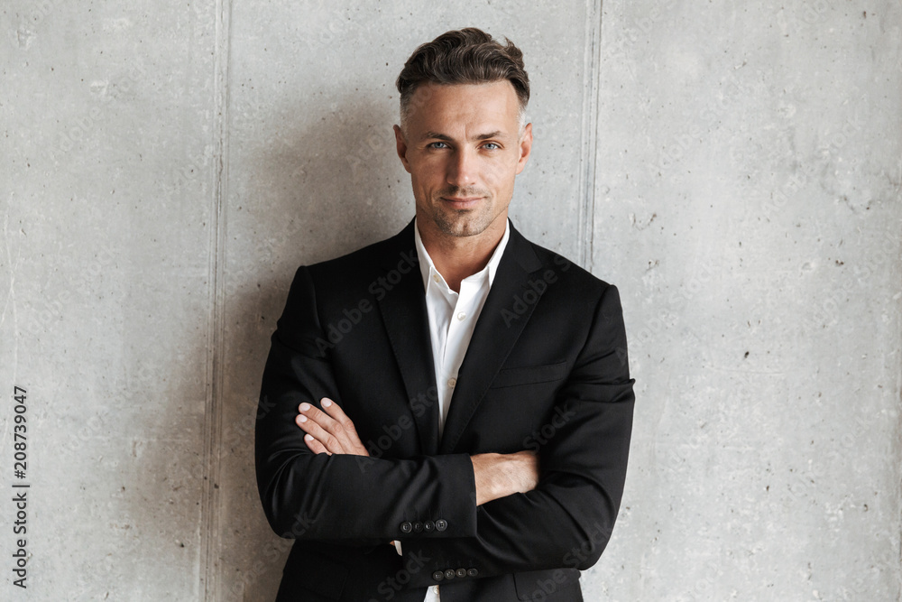Handsome man dressed in suit holding arms folded Handsome man dressed in suit holding arms folded