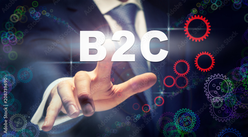 A businessman pressing a B2C business concept on a graphical display of cogs A businessman pressing a B2C business concept on a graphical display of cogs
