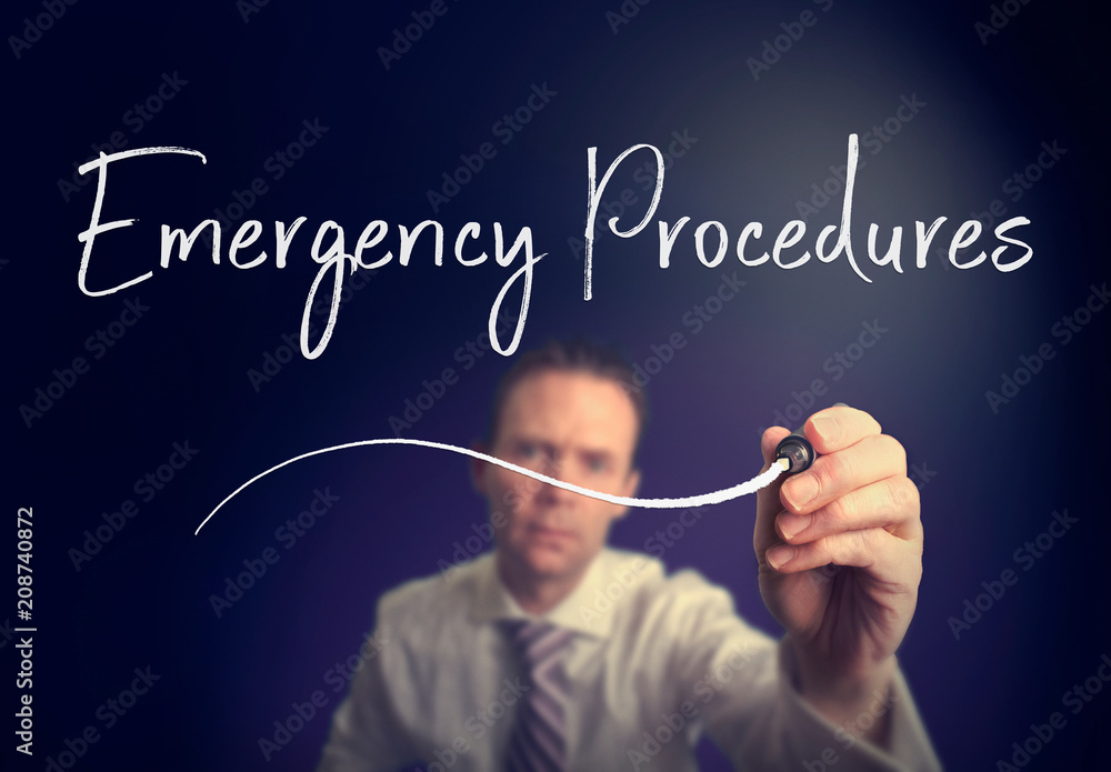 A businessman writing a Emergency Procedures concept with a white pen on a clear screen. A businessman writing a Emergency Procedures concept with a white pen on a clear screen.