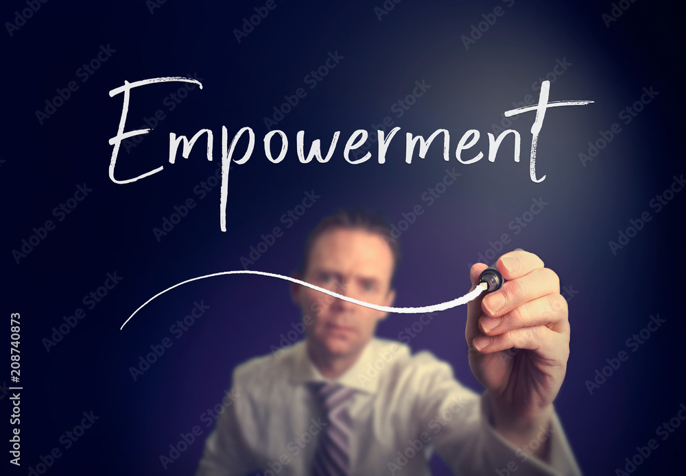 A businessman writing a Empowerment concept with a white pen on a clear screen. A businessman writing a Empowerment concept with a white pen on a clear screen.