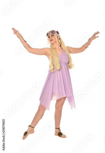 full length portrait of pretty blonde girl wearing purple fairy dress. standing pose, isolated on white studio background.