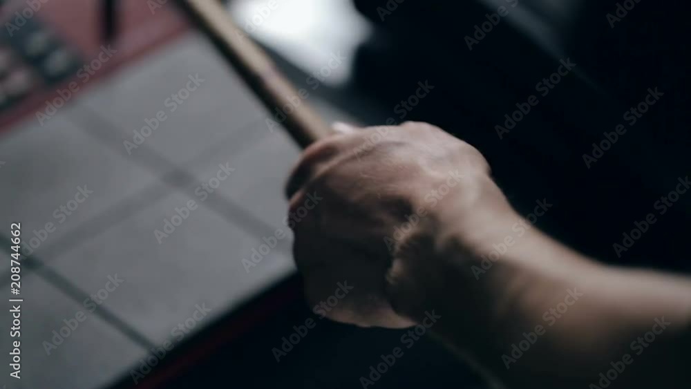 Close up shot of man's hands drum sticks on sampler and electronic pads Close up shot of man's hands drum sticks on sampler and electronic pads