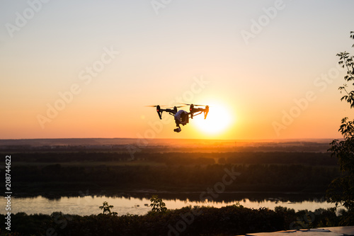 silhouette of drone  quadrocopter with photo camera flying in the sky.