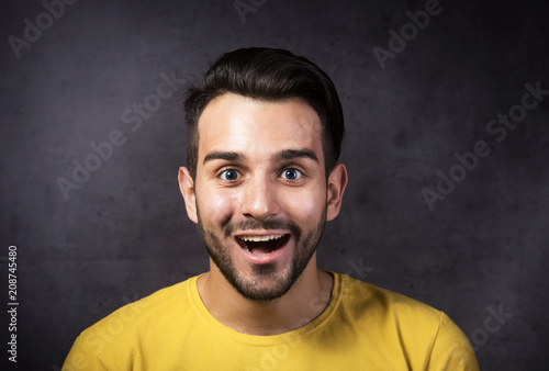 Studio portrait of a smiling youth looking at camera, gray background