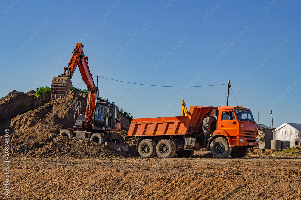 Loading of land with an excavator in a dump truck Loading of land with an excavator in a dump truck