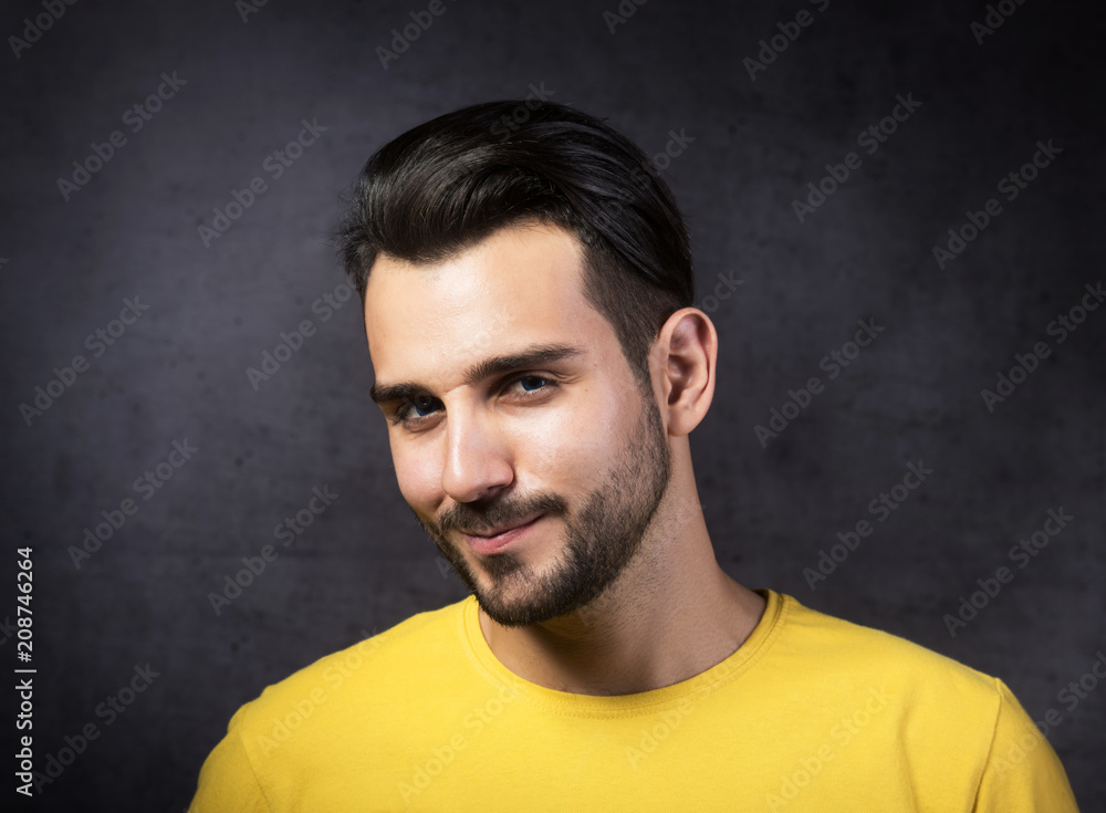 Studio portrait of a smiling youth looking at camera, gray background Studio portrait of a smiling youth looking at camera, gray background