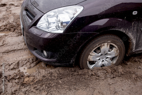 Fotografi the car is stuck on a bad road in the mud