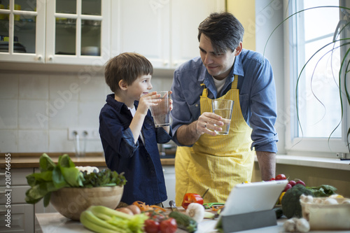 Father and son cooking in kitchen photo