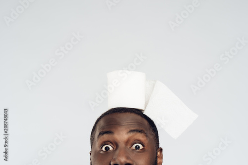 Cropped black man holds roll of toilet paper