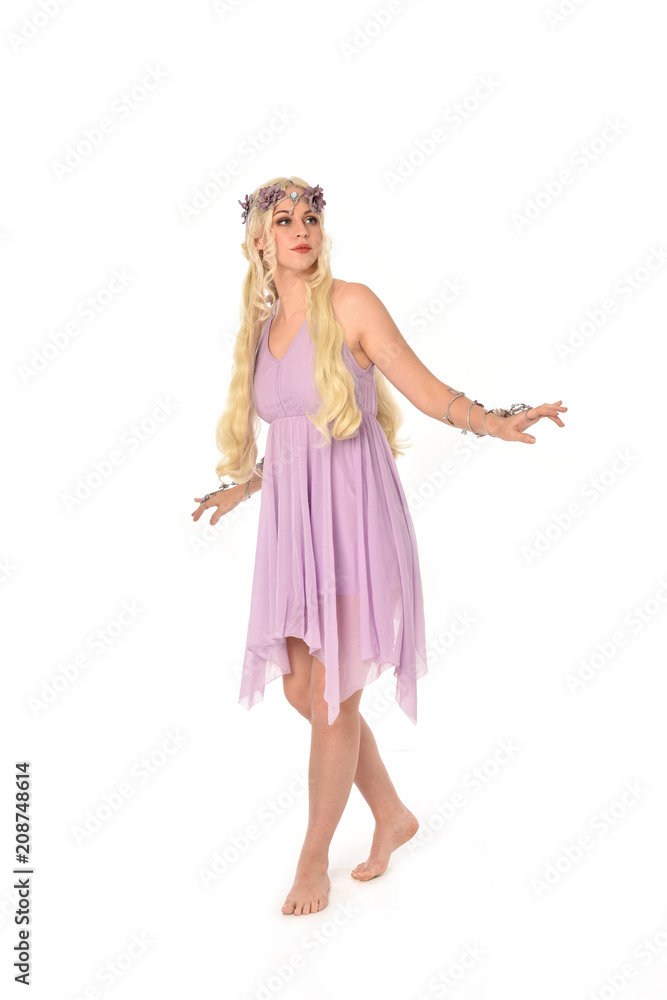 full length portrait of pretty blonde girl wearing purple fairy dress. standing pose, isolated on white studio background. full length portrait of pretty blonde girl wearing purple fairy dress. standing pose, isolated on white studio background.