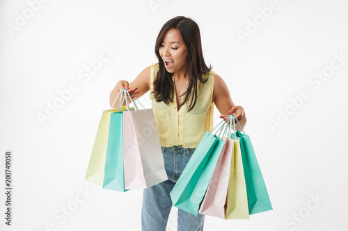 Excited young asian woman with shopping bags.
