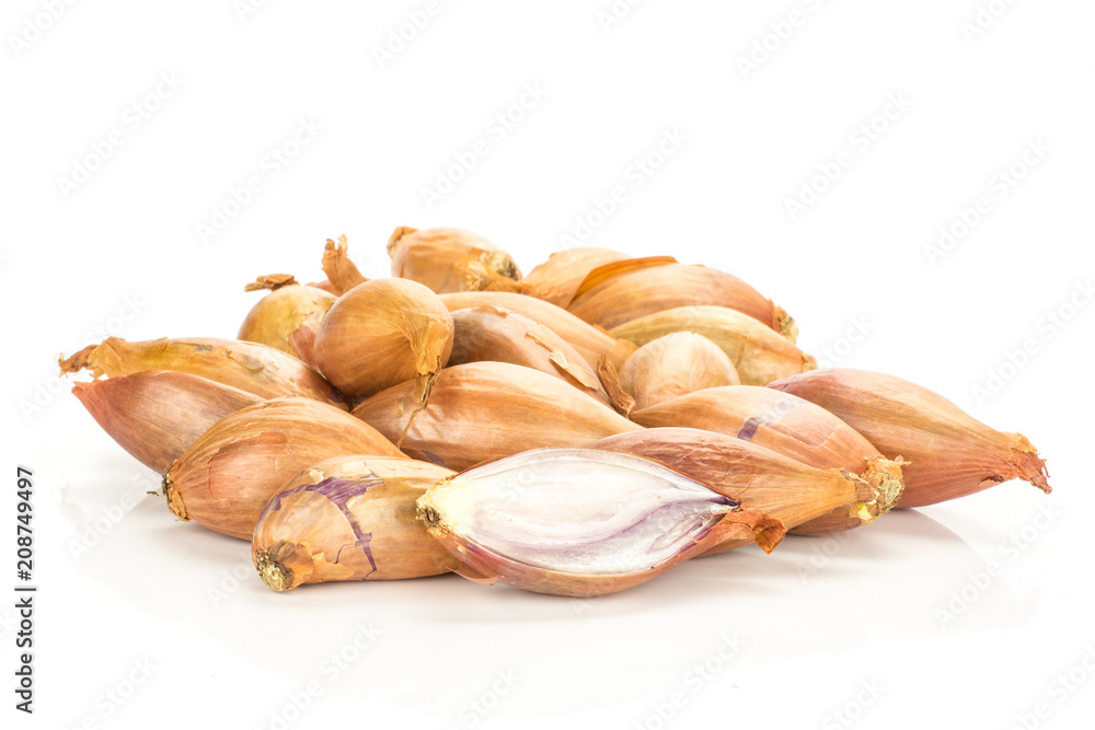 Golden shallots stack and one sliced half isolated on white background.