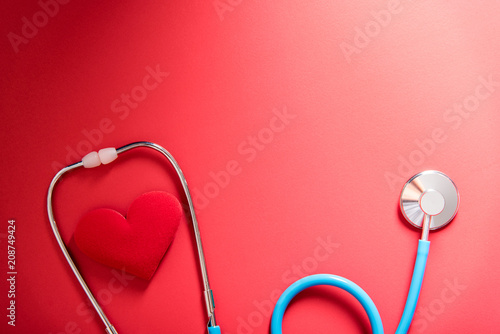 red heart and stethoscope on red background