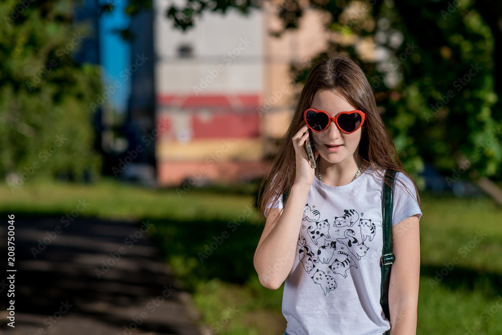 Girl Brunette Teen. In the summer in park in the fresh air. He talks on the phone. Dressed in sunglasses in the form of hearts. Free text field. Conversation with parents On the phone after school. Girl Brunette Teen. In the summer in park in the fresh air. He talks on the phone. Dressed in sunglasses in the form of hearts. Free text field. Conversation with parents On the phone after school.