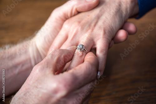 Man putting a ring on woman s finger