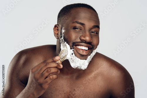 African American man smears shaving cream photo
