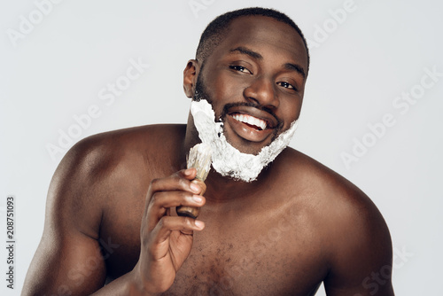 African American man smears shaving cream