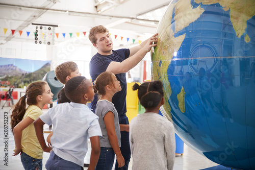 Kids watch presentation with giant globe at a science centre photo