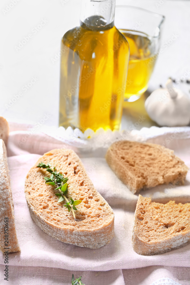 Cut bread and bottle of olive oil on table