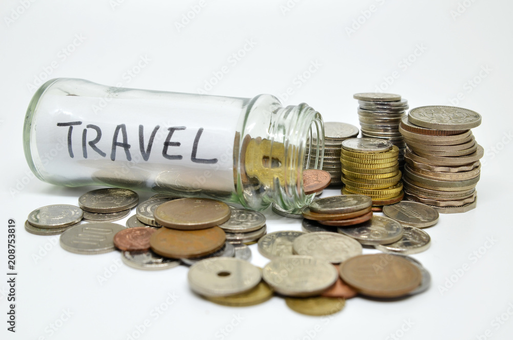 Travel lable in a glass jar with coins spilling out Travel lable in a glass jar with coins spilling out
