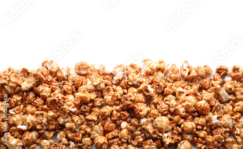 Delicious popcorn with caramel on white background