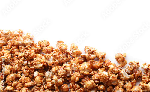 Delicious popcorn with caramel on white background