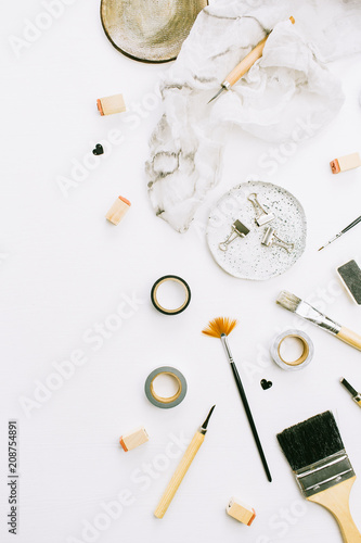 Artist home office desk workspace with paint brushes and tools on white background. Flat lay, top view creative minimal mock up template.