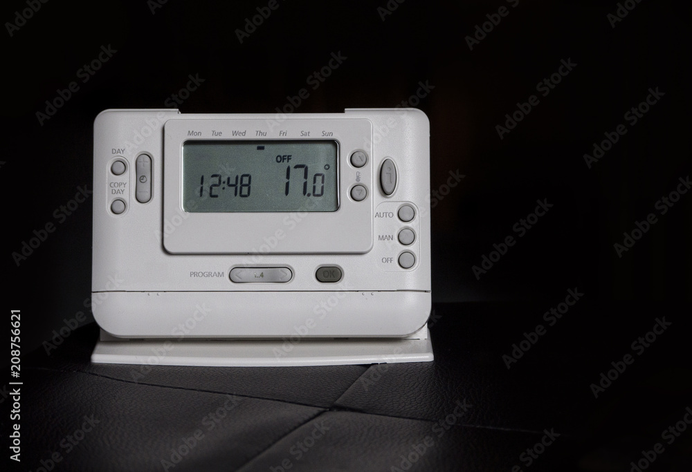 Home radio-controlled thermostat isolated on black.