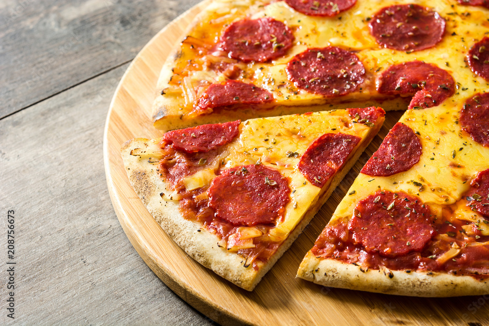 Hot italian pepperoni pizza sliceon wooden table. Hot italian pepperoni pizza sliceon wooden table.