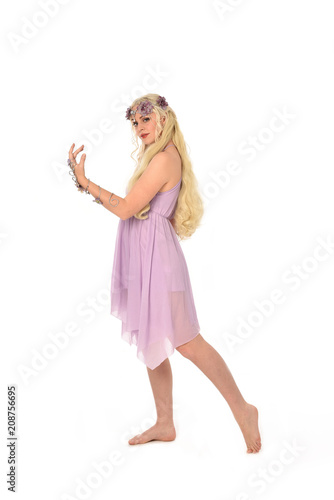 full length portrait of pretty blonde girl wearing purple fairy dress. standing pose  isolated on white studio background.