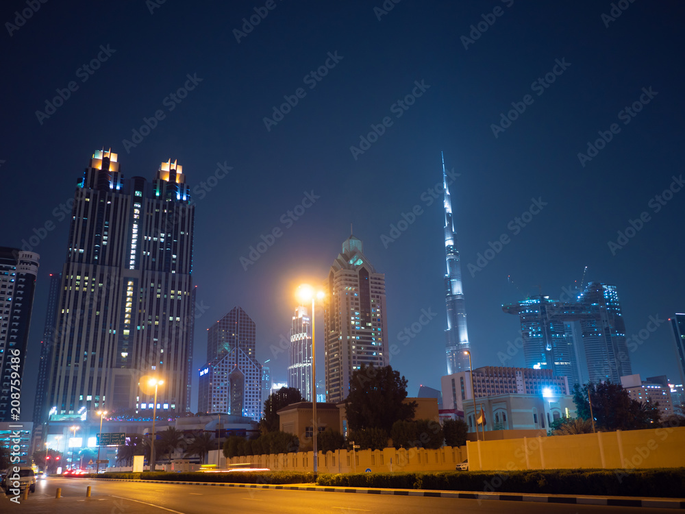 Dubai skyscrapers at night with road at night.