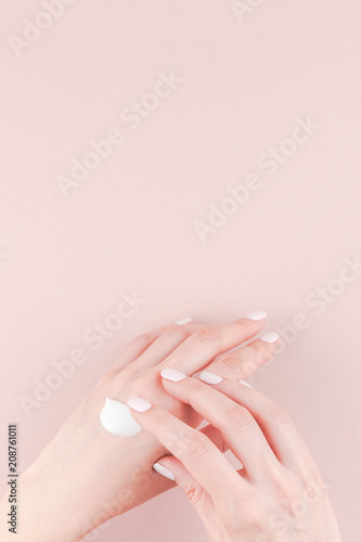 Woman moisturizing her hand with cosmetic cream