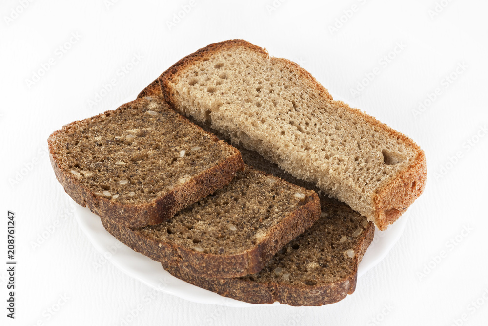 Black and white bread on a white plate on a white isolated background. Black and white bread on a white plate on a white isolated background.