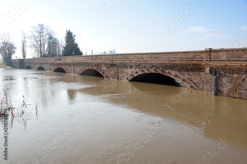 bridge with full river . River is full . Bridge to cross the river that is flooding.