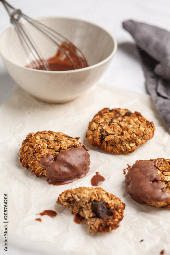 Vegan oatmeal cookies with chocolate on a white table background. Food blog style concept. Vegan oatmeal cookies with chocolate on a white table background. Food blog style concept.