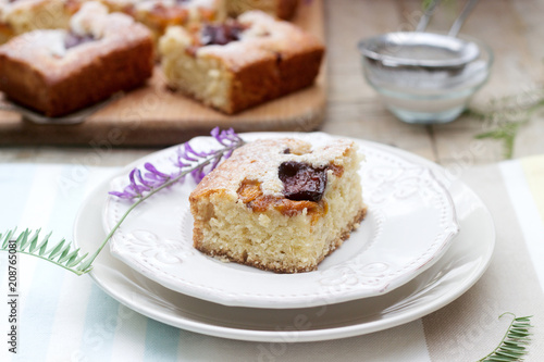 Wallpaper Mural Pieces of fruit pie with pieces of plums and peach and a bouquet of flowers on a wooden table. Rustic style. Torontodigital.ca