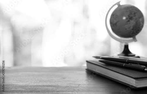 A pen on the desk with small globe