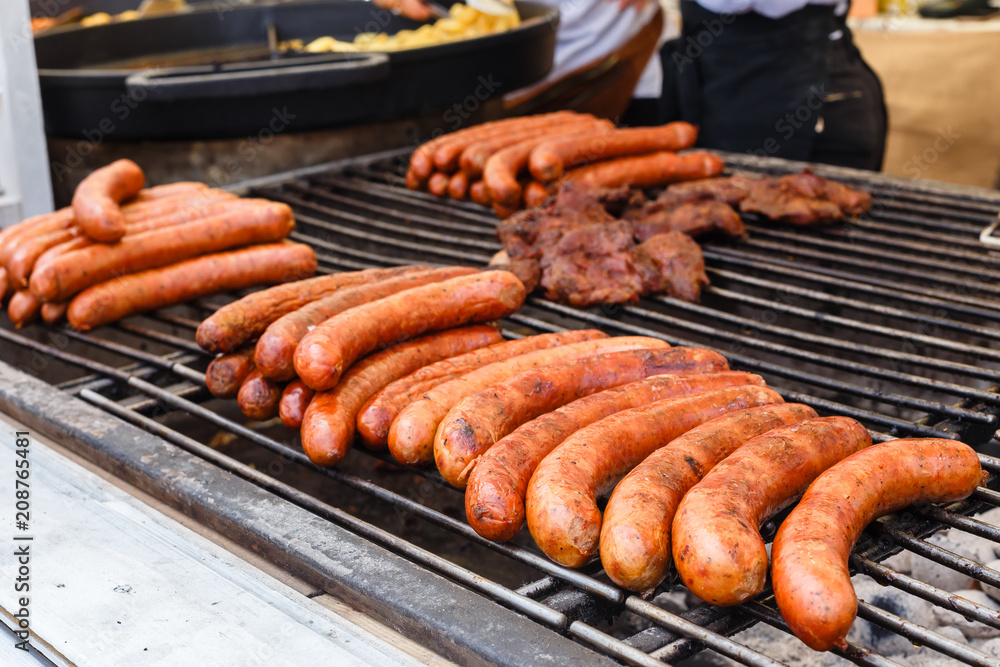 Street food, fast food, Cook fry delicious grilled sausages Street food, fast food, Cook fry delicious grilled sausages