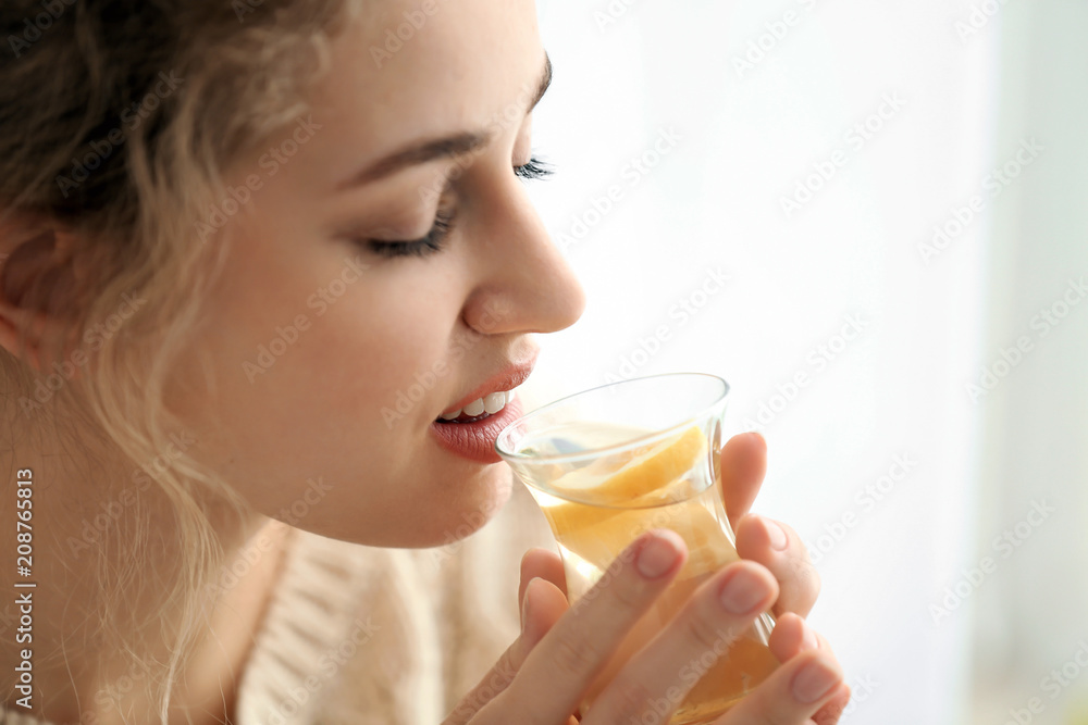 Young woman drinking white tea on light background Young woman drinking white tea on light background