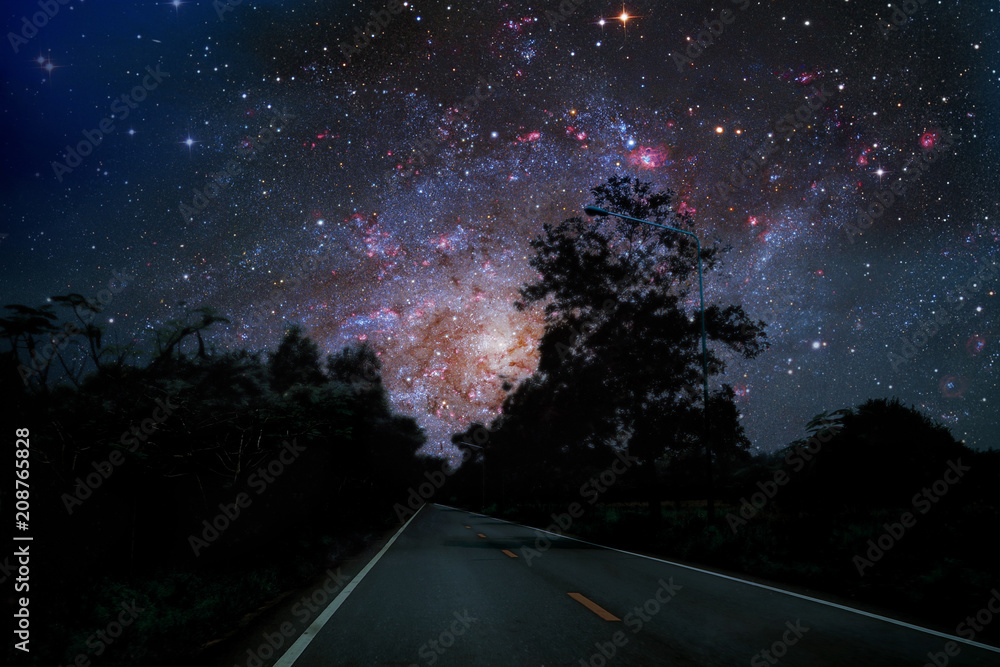Naklejka premium Galaxy on night sky over country road