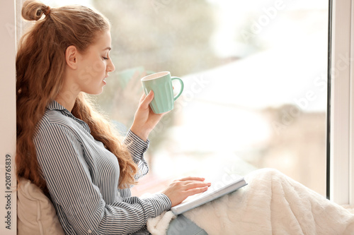 Young woman drinking tea wh...