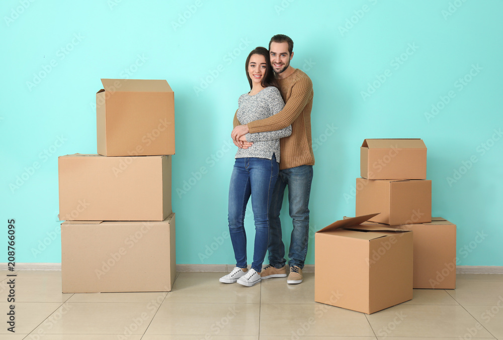 Young couple hugging near boxes indoors. Moving into new house Young couple hugging near boxes indoors. Moving into new house