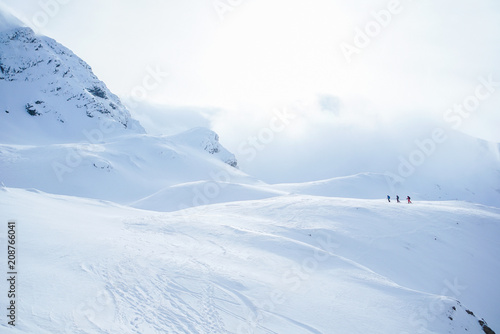 Aerial View of Group of touring skiers. Ski touring in the mountains. From Above. Ski tour group. Free ride in Romania. Winter sunny day. Winter sport. Group of alpine touring skiers