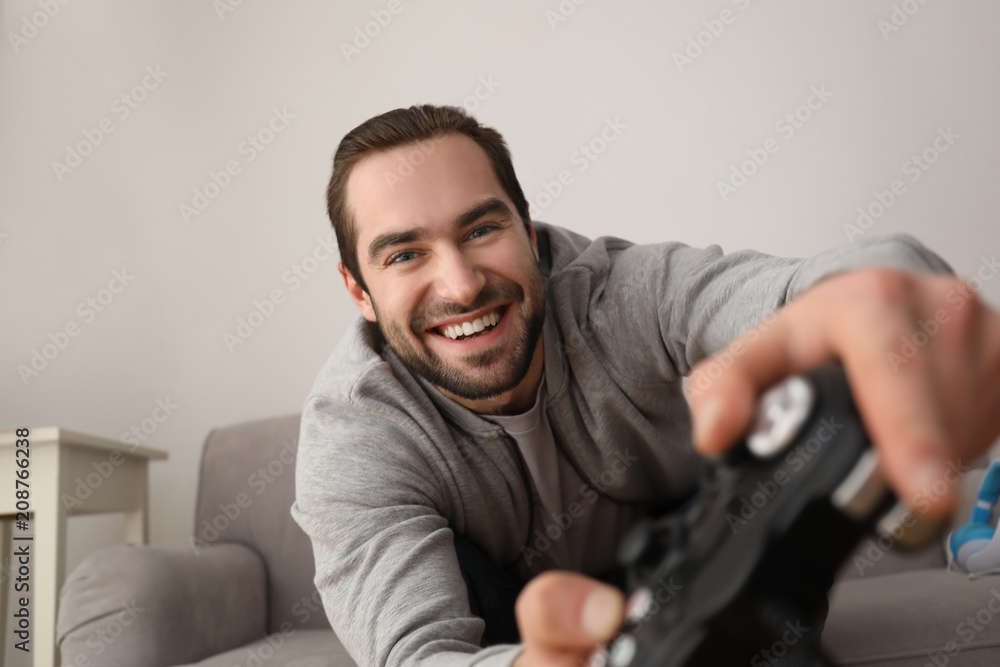 Young man playing video games at home