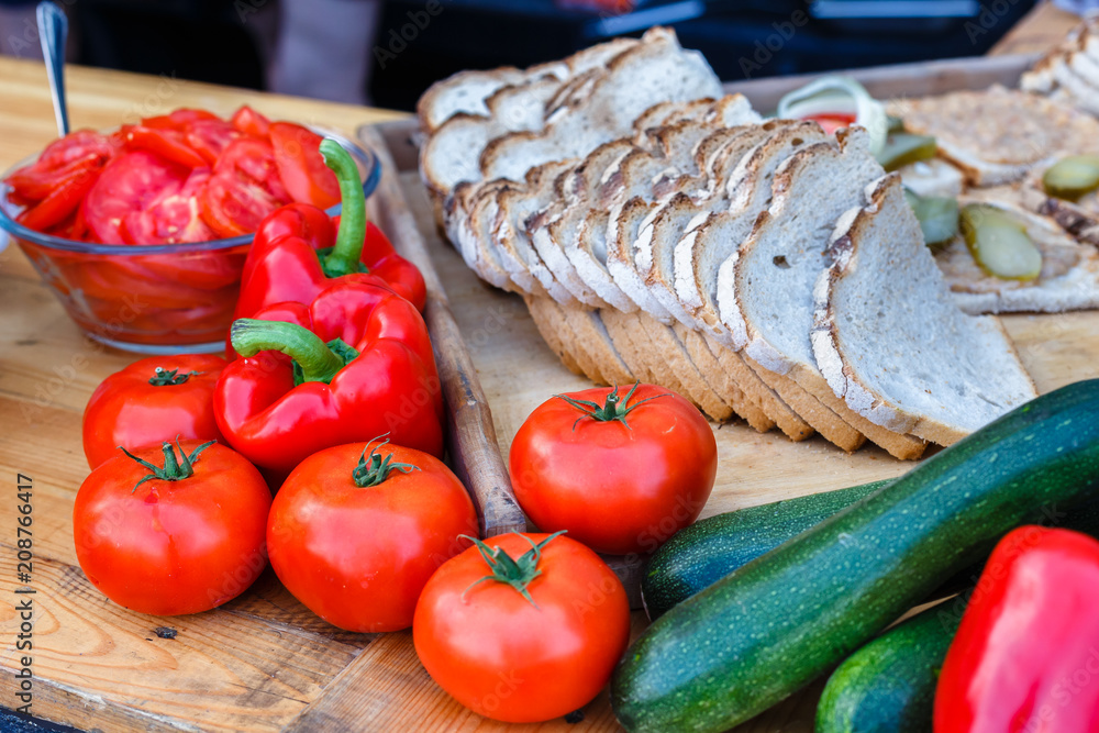 Fresh vegetables - tomatoes, zucchini and bread on a picnic table on a summer day. Fresh vegetables - tomatoes, zucchini and bread on a picnic table on a summer day.