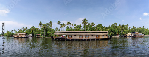 Panoramic river view and traditional house boat in Kerala's Backwaters, India.
