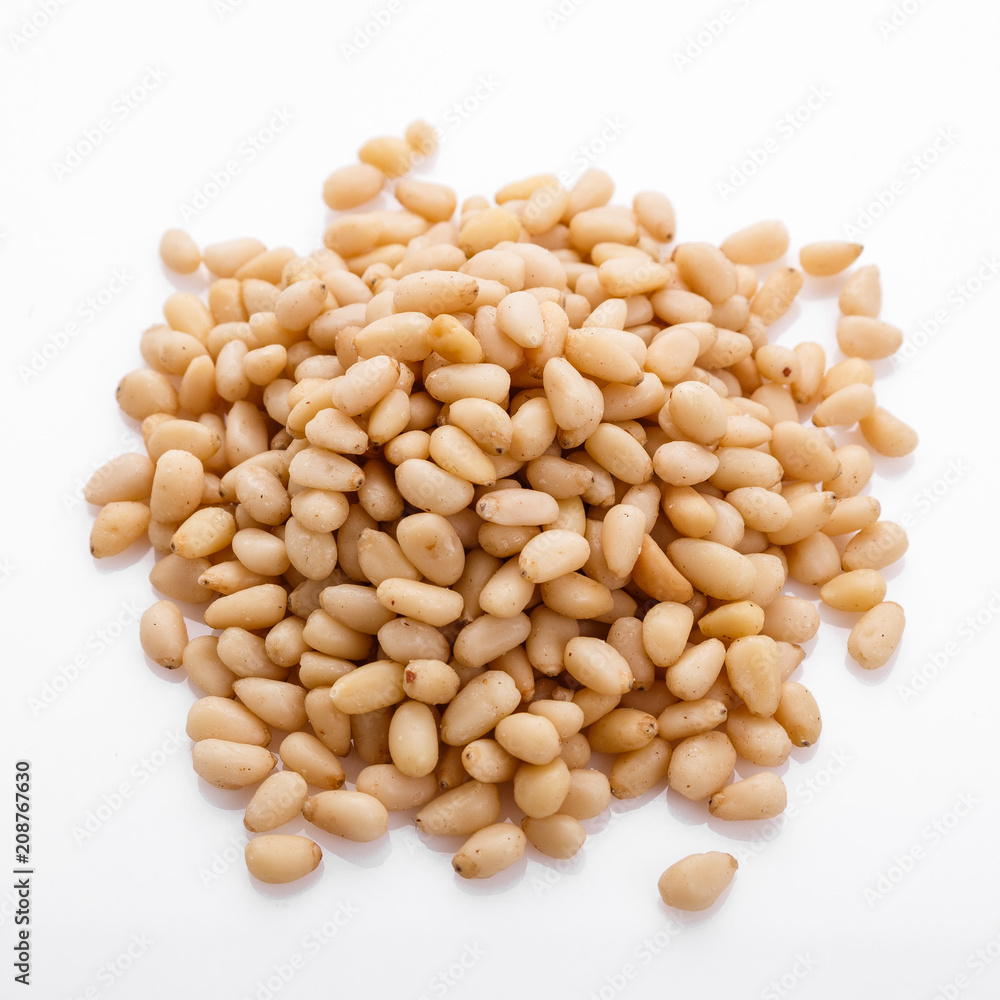peeled pine nuts on a white acrylic background peeled pine nuts on a white acrylic background