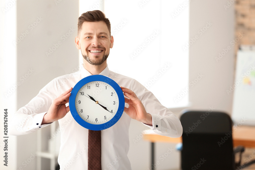 Businessman with clock in office. Time management concept Businessman with clock in office. Time management concept